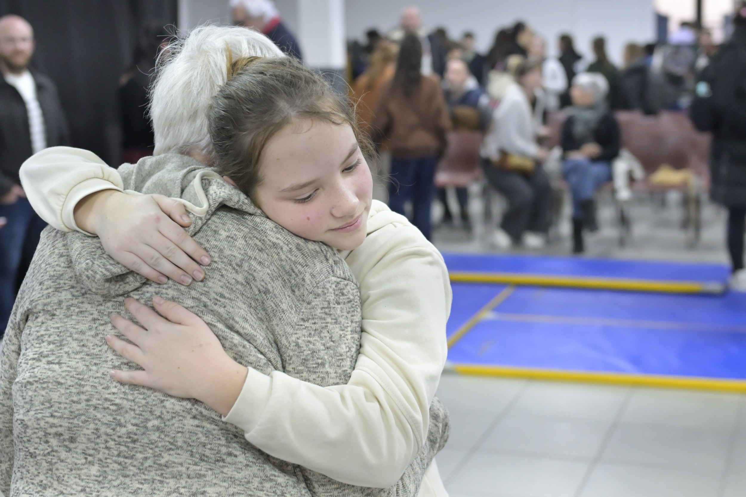 une petite fille fais un câlin à une femme âgée.
